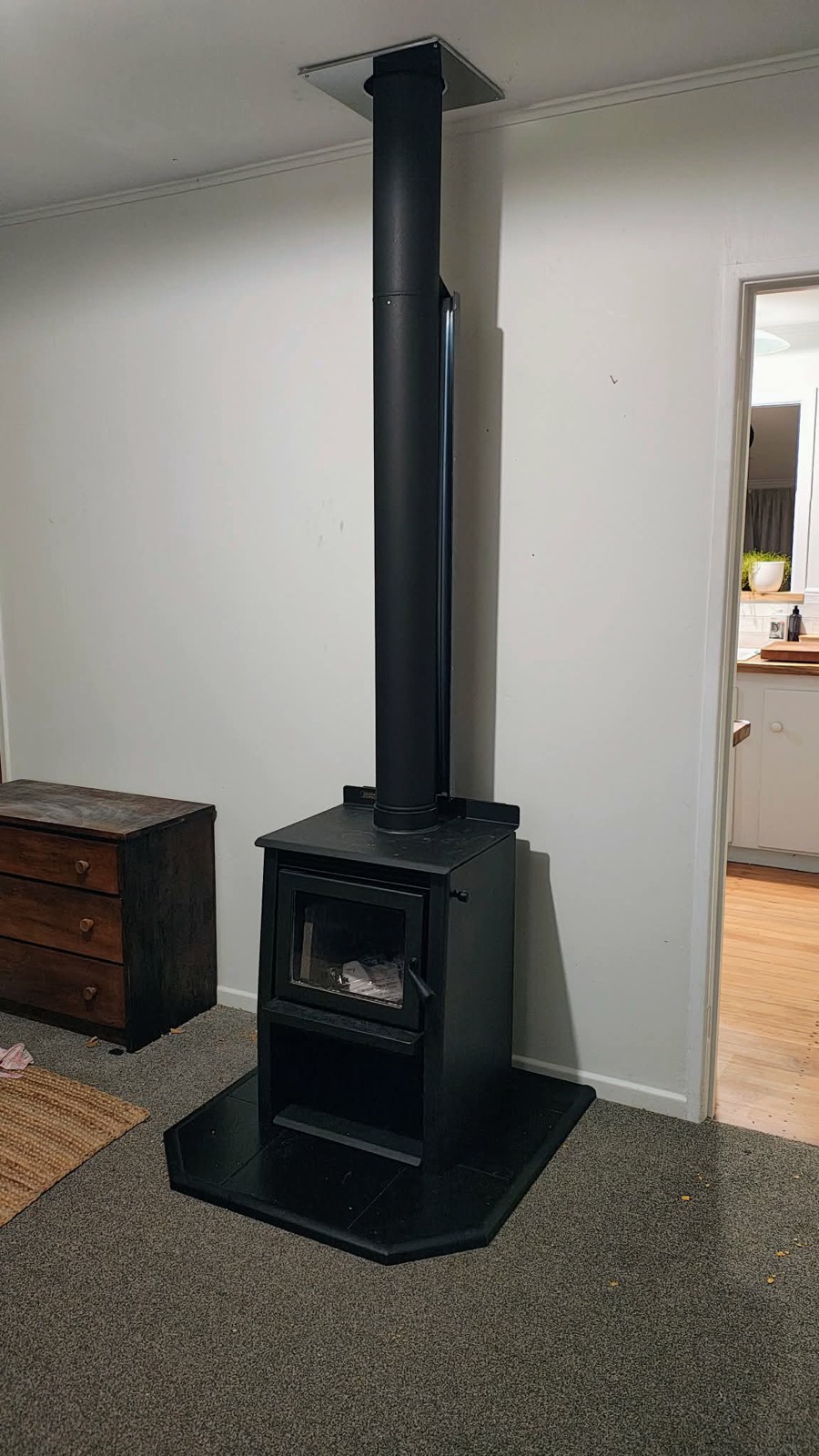 Black freestanding wood fire with a tall flue in a Northland lounge
